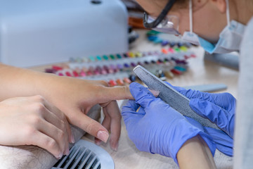 closeup of manicurist at work in the salon nail (shallow DOF; co