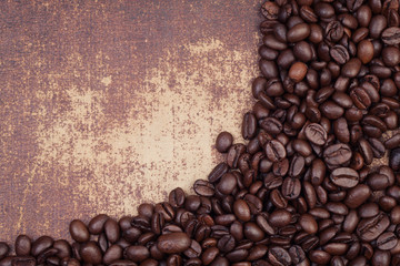 Dark roasted coffee beans on a grungy faux leather material back