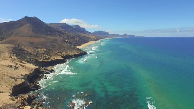 AERIAL: Amazing picturesque sandy beach with huge volcanoes