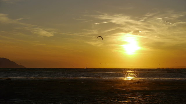Kiteboarder jumping at sunset