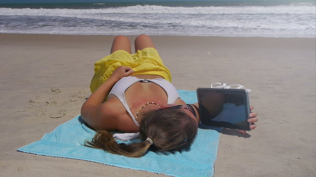 Young woman reading digital tablet on vacations