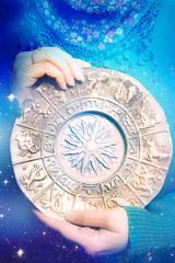 a woman holding a zodiac plate with all astrology signs