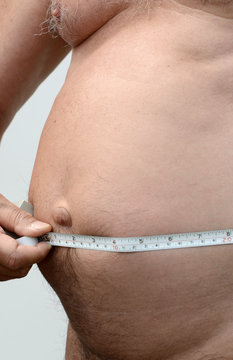 Fat male stomach with tape measure