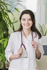 beautiful girl Doctor in a white coat standing in hospital smiling