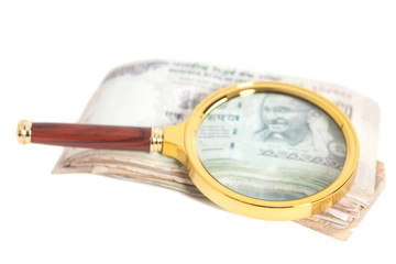 Indian Currency Rupee Notes with magnifying glass