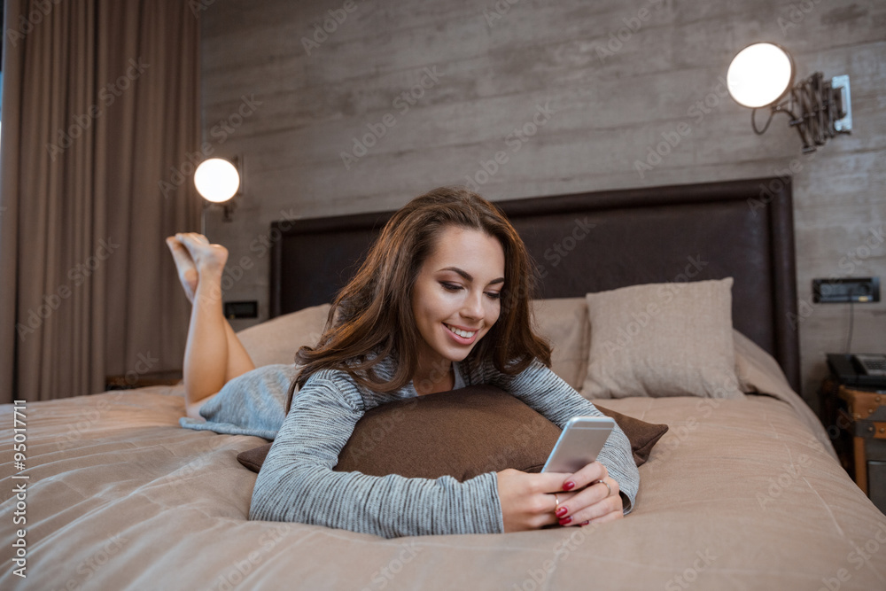 Poster woman lying on the bed and using smartphon