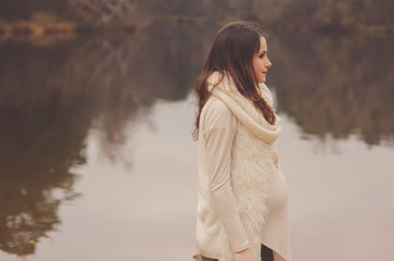 pregnant woman walks outdoor, cozy mood, soft warm toned