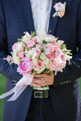 groom hold wedding bouquet in hand