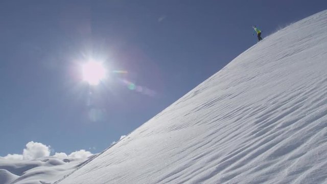 SLOW MOTION: Snowboarder sprays fresh snow into the camera