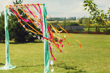 good color wedding arch on a background of green grass and sky