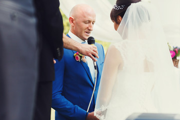 charismatic adult bride and groom on their knees giving each oth