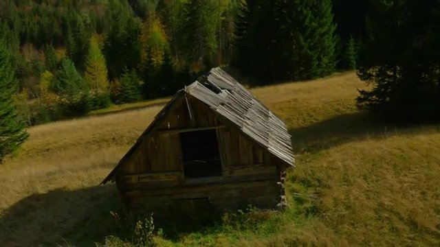 AERIAL: Old shepherd's hut on glade in the mountains