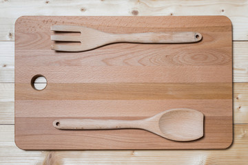 Wooden spatula and fork on the cutting board