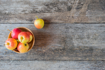 Apples in a wood bowl on wooden background.