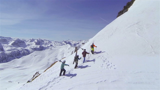 AERIAL: Skiers hiking up big mountain in Austria 