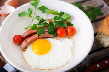 Fried eggs with sausage and tomatoes