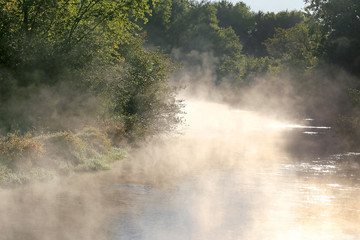 Fototapeta na wymiar Foggy Morning with Steam Rising off River