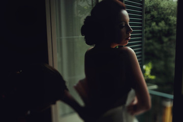wonderful stylish sweet brunette bride standing at the window pu