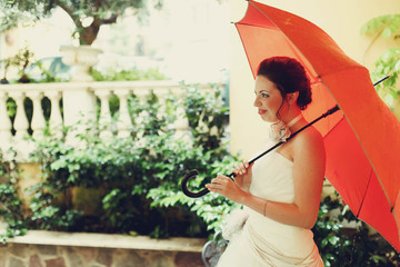 amazing beautiful rich stylish smiling bride under red umbrella