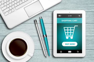 tablet with shopping cart site, computer and coffee