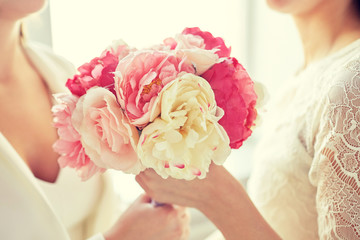 close up of happy lesbian couple with flowers