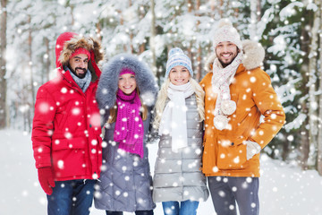 group of smiling men and women in winter forest
