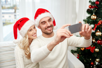 couple taking selfie with smartphone at christmas