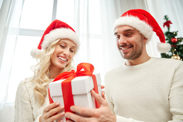 happy couple at home with christmas gift box