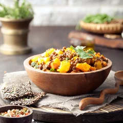 Photo sur Plexiglas Plats de repas Lentilles aux carottes et ragoût de citrouille dans un bol en bois.
