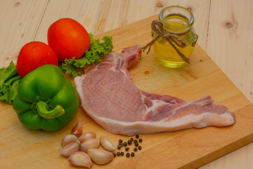 Raw steak with ingredient on wooden board