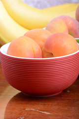 bananas and apricots on red plate, close up