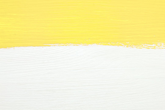 Stripe Of Yellow Paint Over White Wooden Background