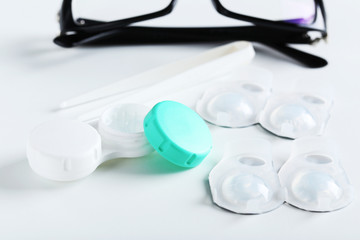 Contact lenses in container with solution on white background