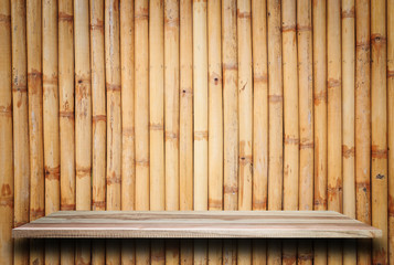 Empty top wooden shelves and bamboo wall background