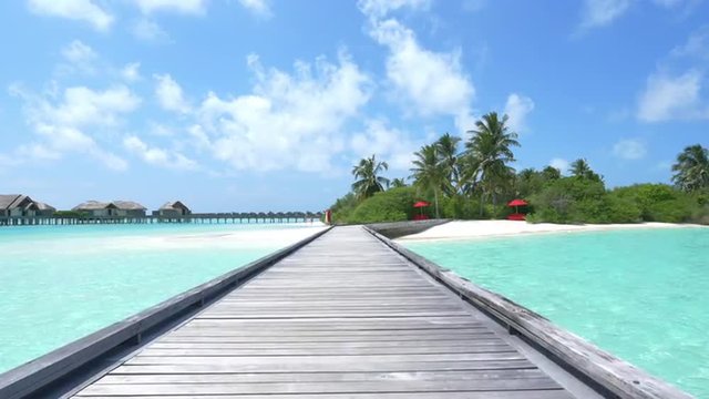Wooden jetty leading from water villas to the beach in Maldives