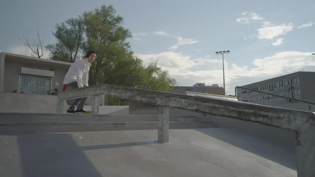 SLOW MOTION: Skateboarder boardslide on a rail