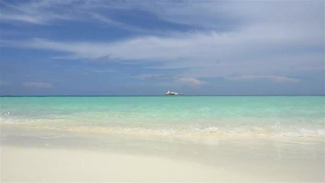 SLOW MOTION: Small waves splashing onto exotic white sand beach