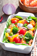 Tasty fried and grilled salmon slices on mixed colorful vegetabl