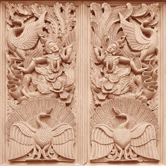 Traditional Thai style wood carving on the wall of Temple in Tha