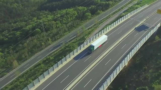 AERIAL: Freight truck transporting cargo over highway viaduct