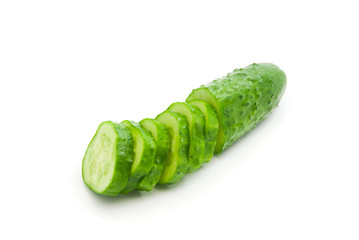 half a cucumber with slices on white