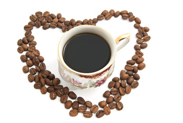 Heart of coffee beans and mug of coffee