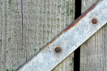 Closeup head of big metal screw on wooden plate