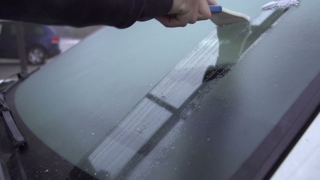 SLOW MOTION: Scraping frosted windshield