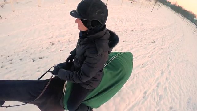CLOSE UP: Smiling female horseback riding in winter