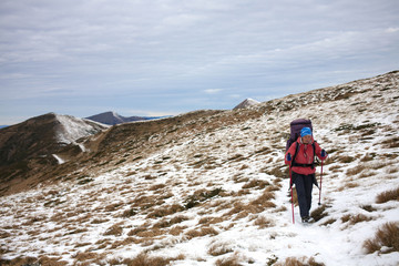 Girl with backpack is traveling in the mountains.