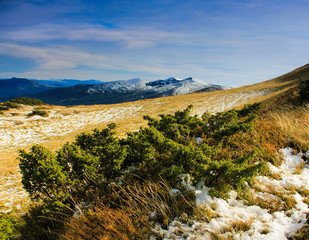 Panoramic views of the autumn mountains and peaks covered with the first snow.
