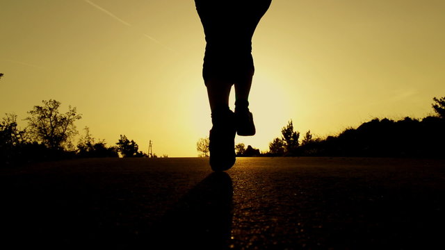 SLOW MOTION: woman running at sunset