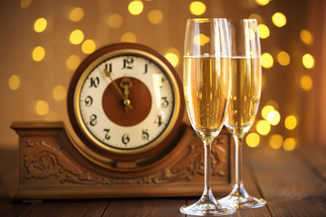 Christmas card. Glasses of champagne on New Year's Eve on the stand an ancient clock