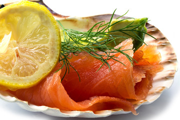 Smoked salmon with avocado, lemon and dill in a scallop shell